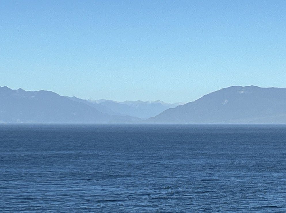 Blick über das offene Meer auf eine Bergkette am Horizont